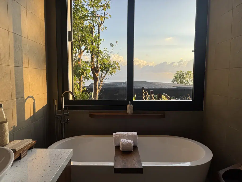 Baignoire Ăźlot devant une fenĂȘtre ouverte sur la mer dans la villa 1 chambre d'Adiwana Warnakali, Nusa Penida