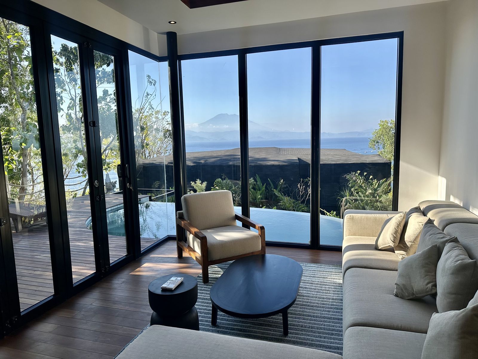 Salon de la villa 1 chambre avec piscine privée d'Adiwana Warnakali, avec la piscine à débordement et le mont Agung au fond
