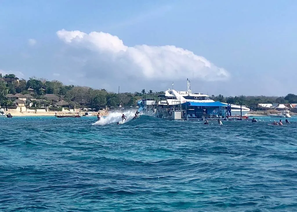 Surfeur prenant une vague de récif au large de la côte de Nusa Lembongan